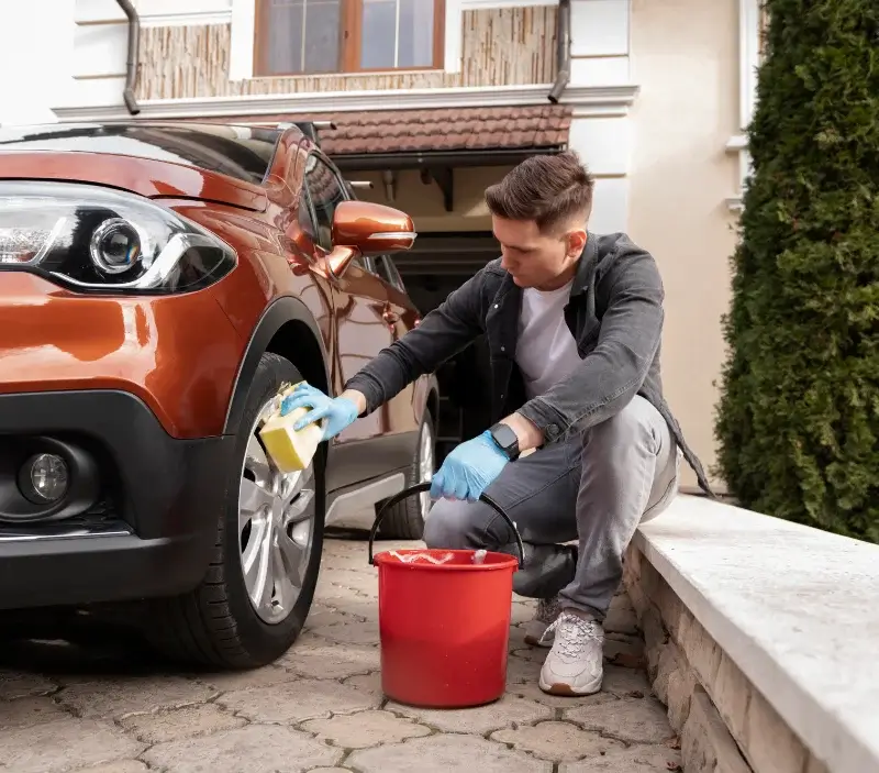 Lavage auto à domicile Malherbe-sur-Ajon : professionnel intervenant sur un véhicule